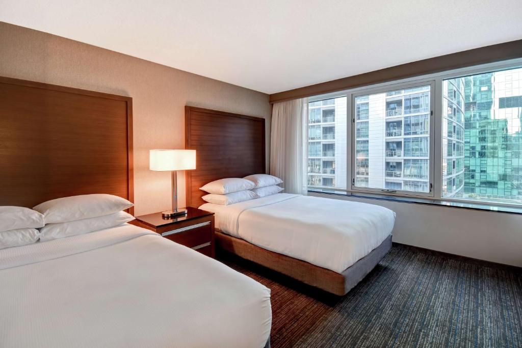 a hotel room with two beds and a large window at Embassy Suites by Hilton Chicago Downtown Magnificent Mile in Chicago