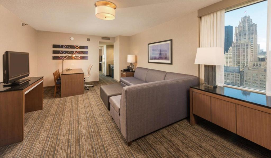 a living room with a couch and a large window at Embassy Suites by Hilton Chicago Downtown Magnificent Mile in Chicago