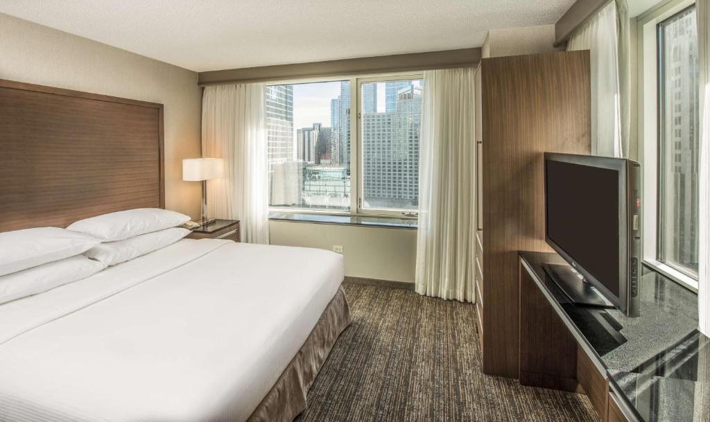 a hotel room with a bed and a flat screen tv at Embassy Suites by Hilton Chicago Downtown Magnificent Mile in Chicago