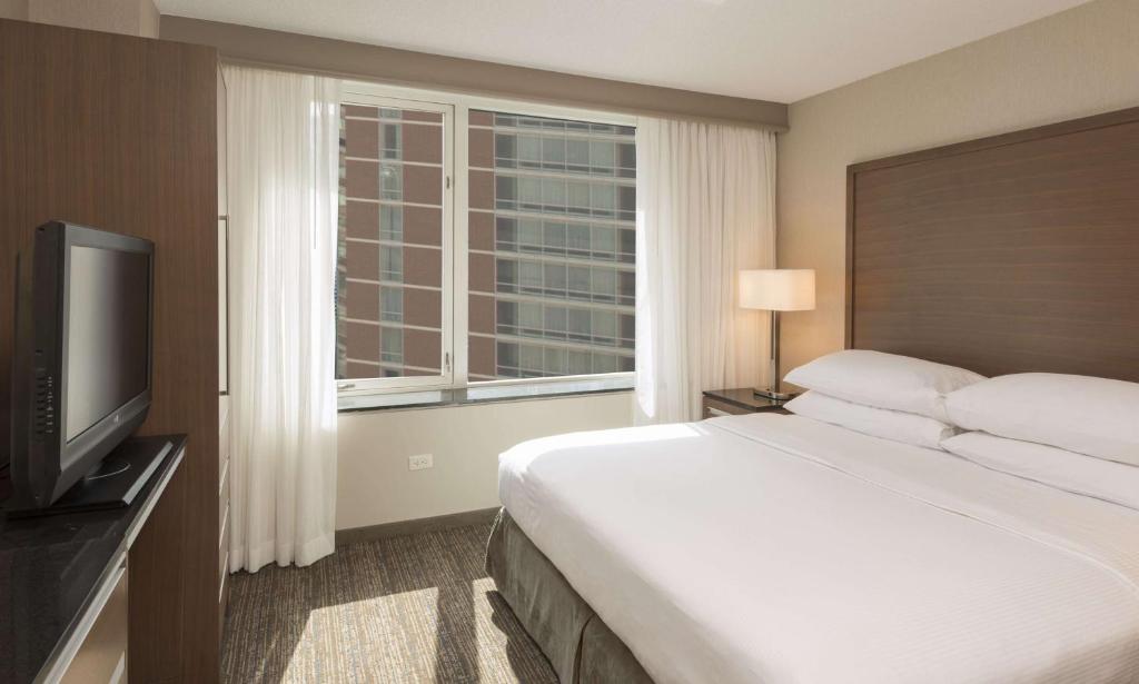 a hotel room with a bed and a window at Embassy Suites by Hilton Chicago Downtown Magnificent Mile in Chicago
