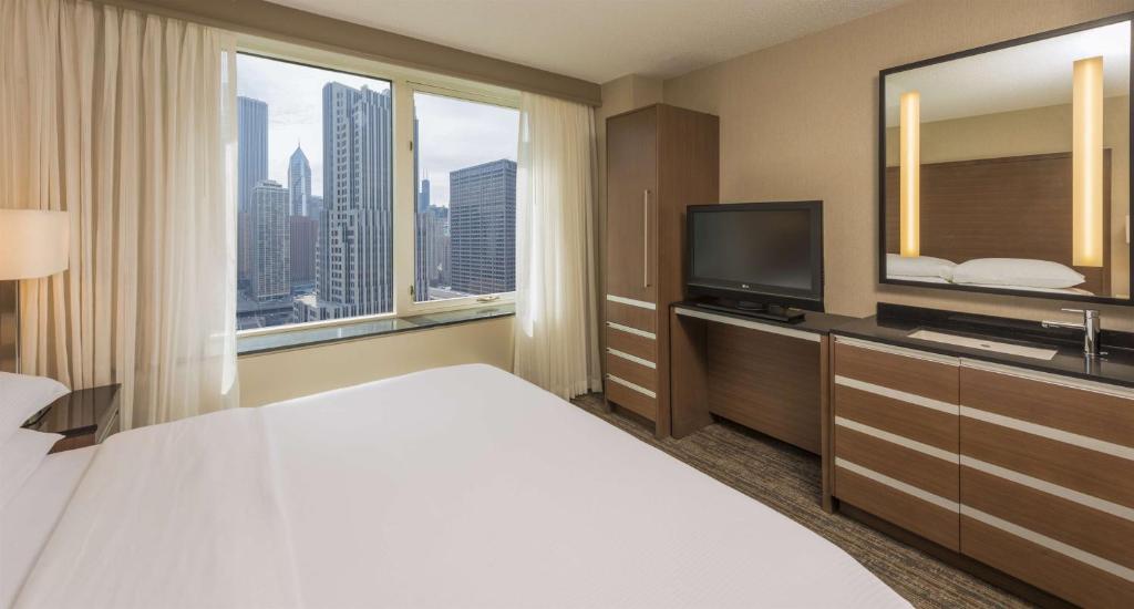 a hotel room with a bed and a flat screen tv at Embassy Suites by Hilton Chicago Downtown Magnificent Mile in Chicago