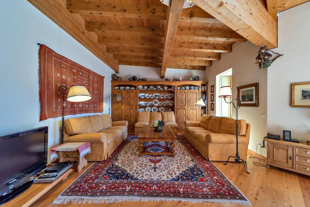 a living room with a couch and a tv at Chesa Roseg - Pontresina in Pontresina