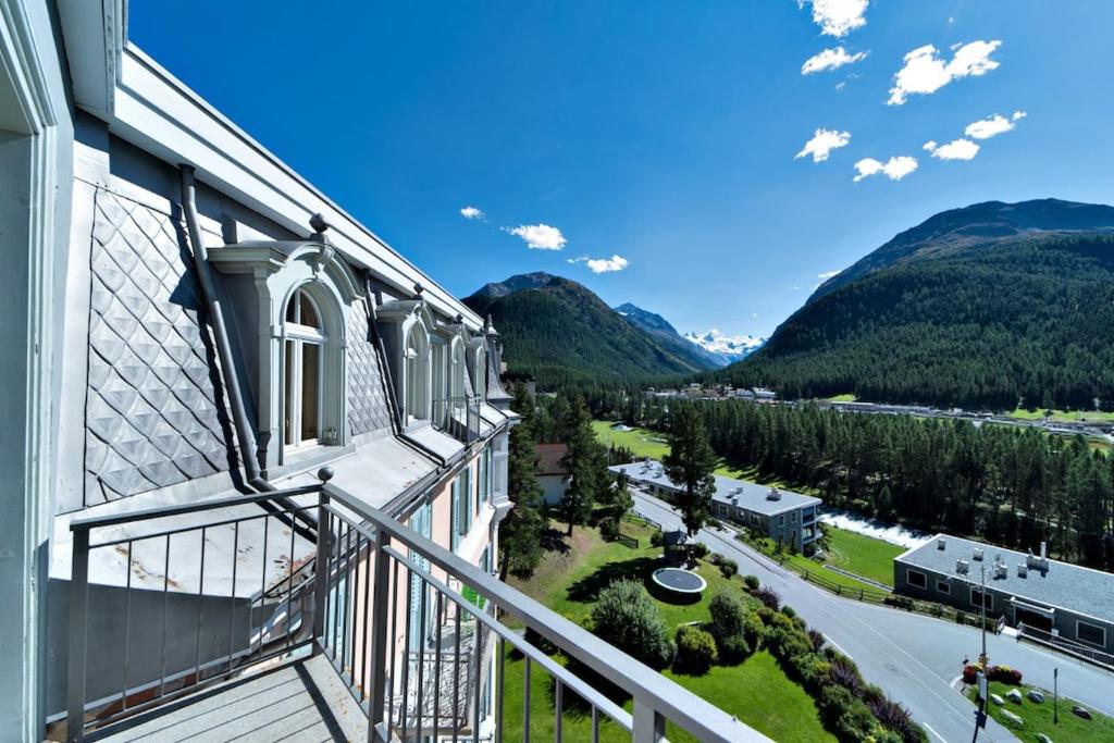 een balkon met uitzicht op een straat en de bergen bij Chesa Roseg - Pontresina in Pontresina