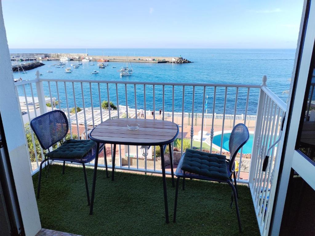une table et des chaises sur un balcon avec l'océan dans l'établissement Vista Puerto Arguineguín Sea View, à Playa de Arguineguín