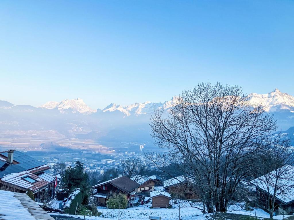 un pueblo cubierto de nieve con montañas en el fondo en Apartment Lau'tentik by Interhome, en Monthey