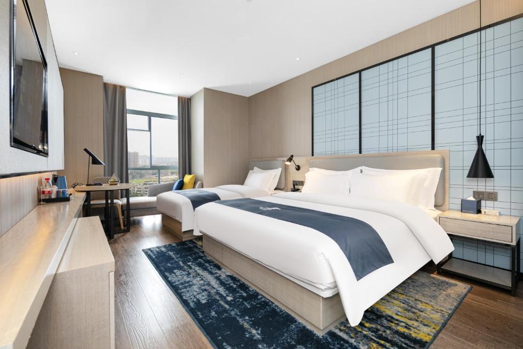 Ένα ή περισσότερα κρεβάτια σε δωμάτιο στο Echarm Hotel - Jingmen Yintai City Jingchu Institute of Technology