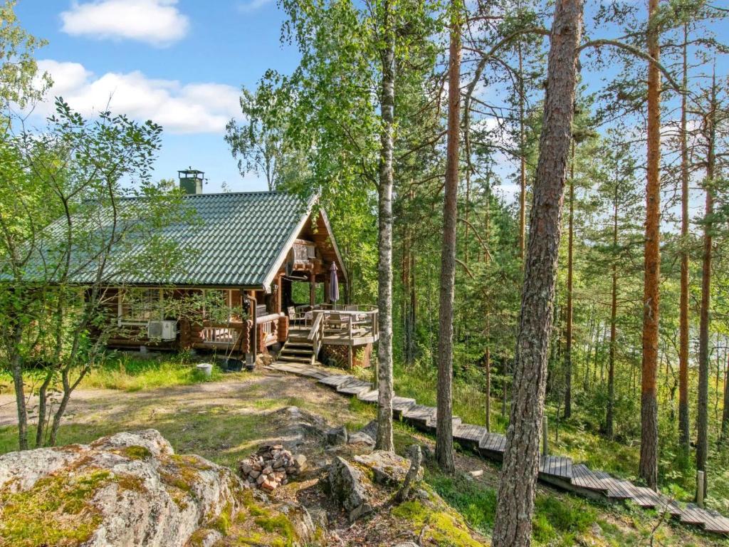 een blokhut in het bos met bomen bij Holiday Home Karhupirtti by Interhome in Mäntyharju