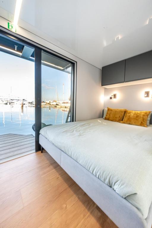 a bedroom with a large bed and a view of the water at The Homeboat Company Albufeira in Albufeira