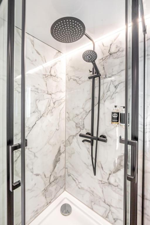 a bathroom with a shower with marble walls at The Homeboat Company Albufeira in Albufeira