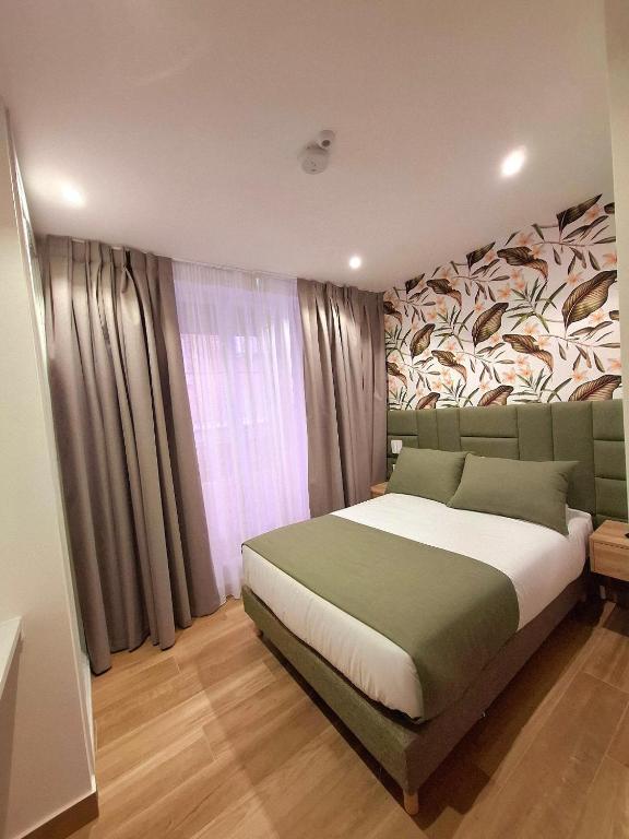 a bedroom with a large bed with a painting on the wall at Hostal San Blas in Madrid