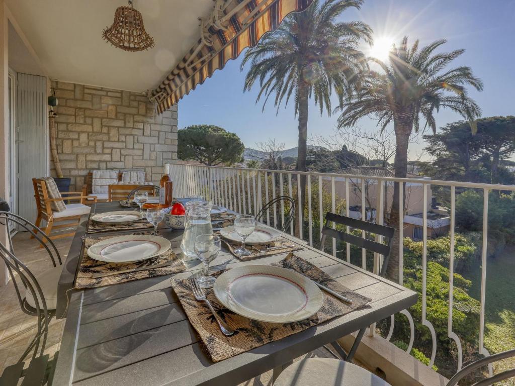 - une table avec des plaques sur le balcon dans l'établissement Apartment Les Palmiers-4 by Interhome, à Saint-Cyr-sur-Mer