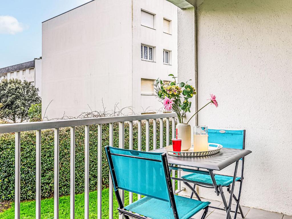 a table and chairs on a balcony with flowers at Apartment Le Zal-4 by Interhome in Quiberon