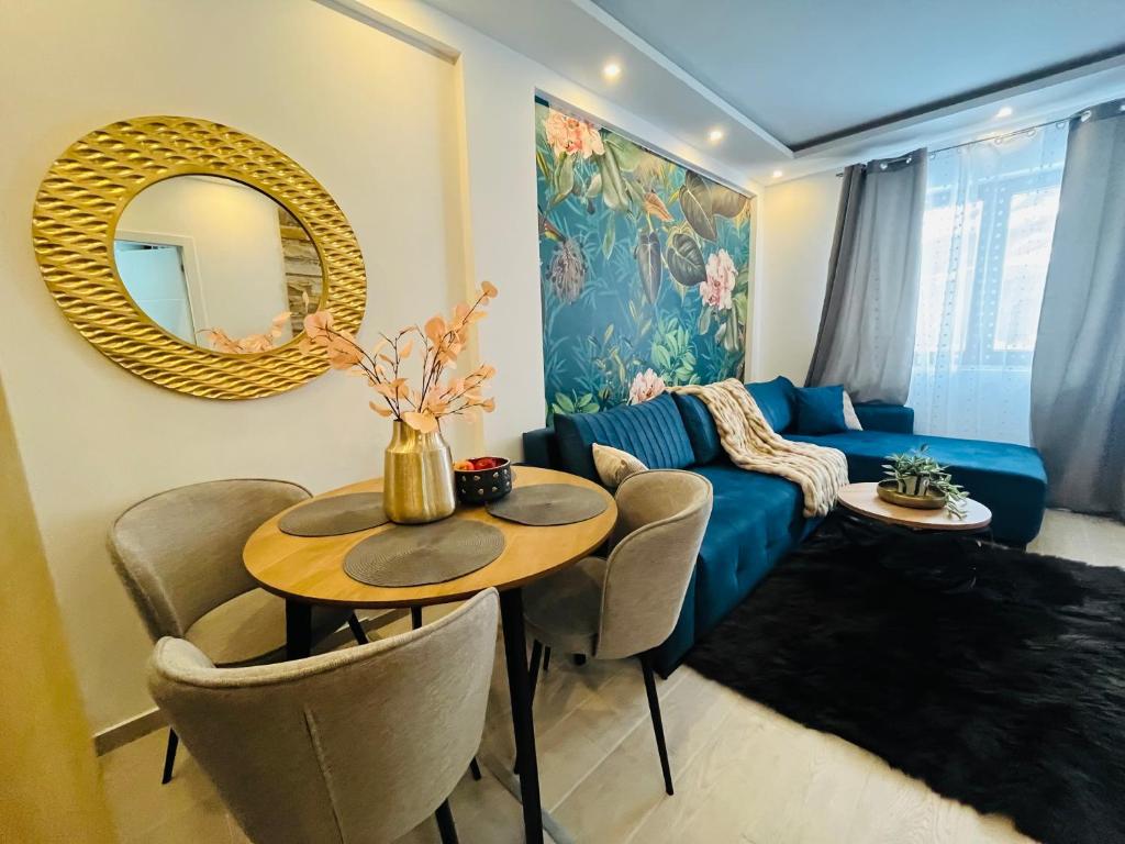 a living room with a blue couch and a table at Gold Apartments Kopaonik in Kopaonik