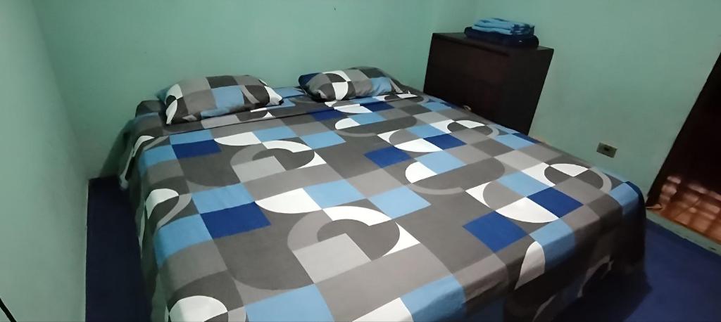 a bedroom with a bed with a checkered blanket at Habitación Doble para 3 o 4 personas full servicio in Valencia