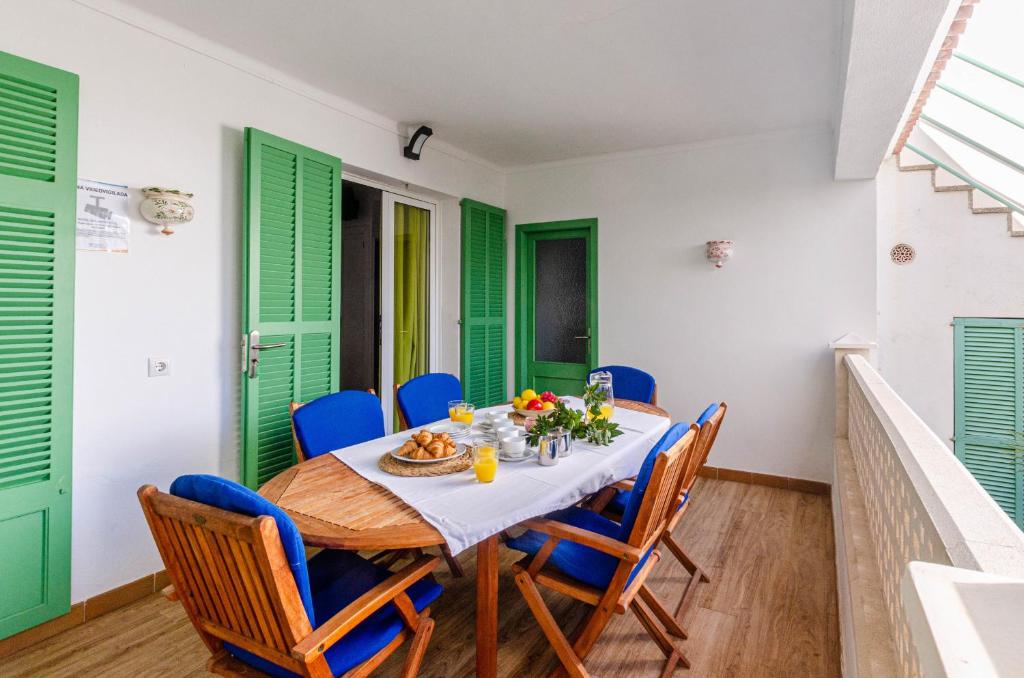 カラ・ラトハダにあるYourHouse Villa Magdalenaのダイニングルーム(緑のシャッター、テーブル、椅子付)