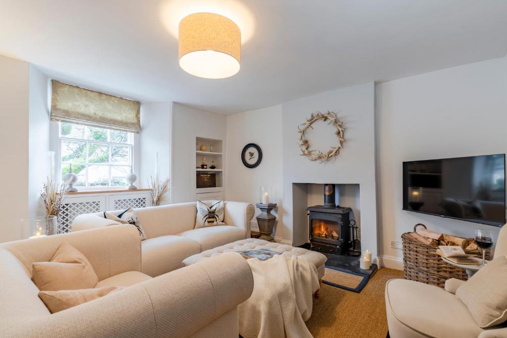 a living room with couches and a fireplace at Antelope Cottage in Northleach