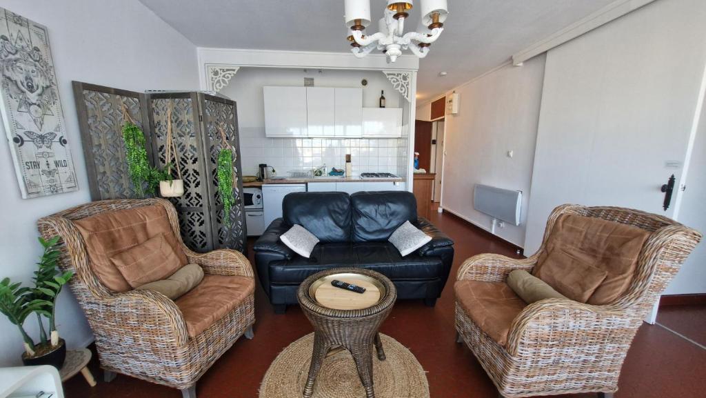 un salon avec deux chaises et un canapé dans l'établissement RESIDENCE DU SOLEIL Spacieux T3 face à la mer au port - Parking, à Saint-Cyprien