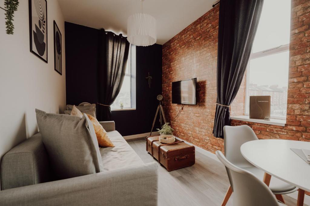 ein Wohnzimmer mit einer Couch und einer Ziegelwand in der Unterkunft Luxury City Apartment-Sleeps 4-Sofa Bed- Free Parking in Nottingham