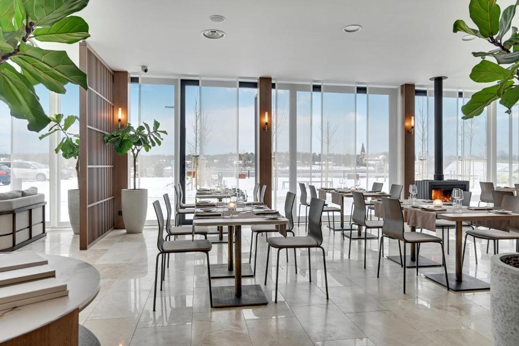 a restaurant with tables and chairs and a fireplace at GRANO HOTEL Solmarina in Wiślinka