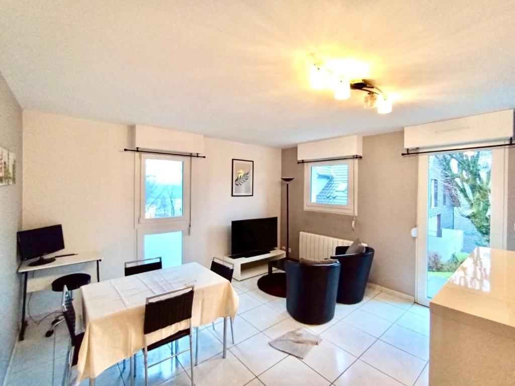 un salon avec une table et une télévision dans l'établissement Charmant studio à Montbéliard, à Montbéliard