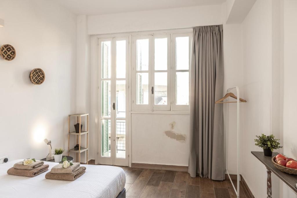 Habitación blanca con cama y ventana grande. en Queen Regina Suites, en Nicosia
