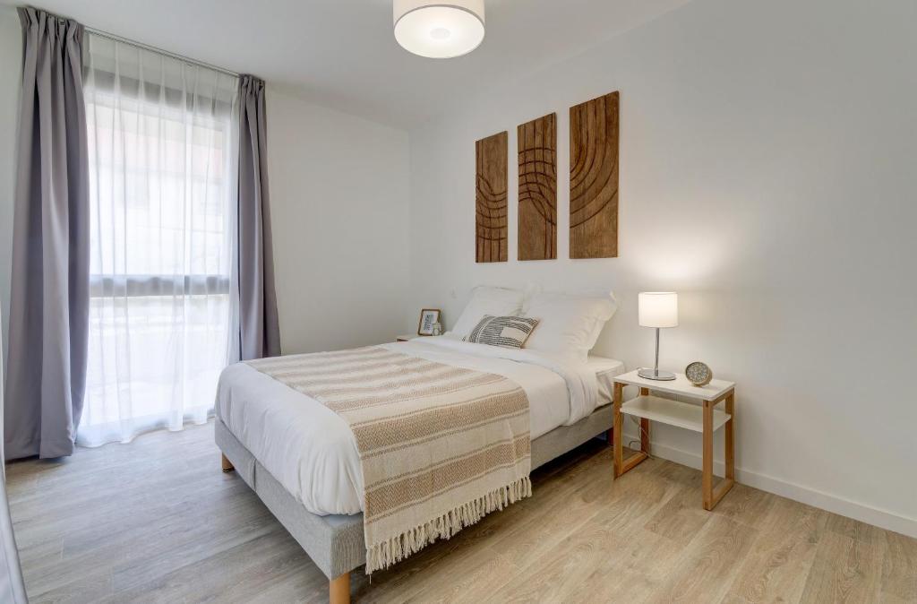 une chambre blanche avec un grand lit et une fenêtre dans l'établissement Résidence de Nogent sur Marne, à Nogent-sur-Marne