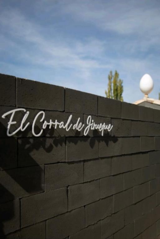 a sign on the side of a brick wall at El Corral de Jirueque in Jirueque