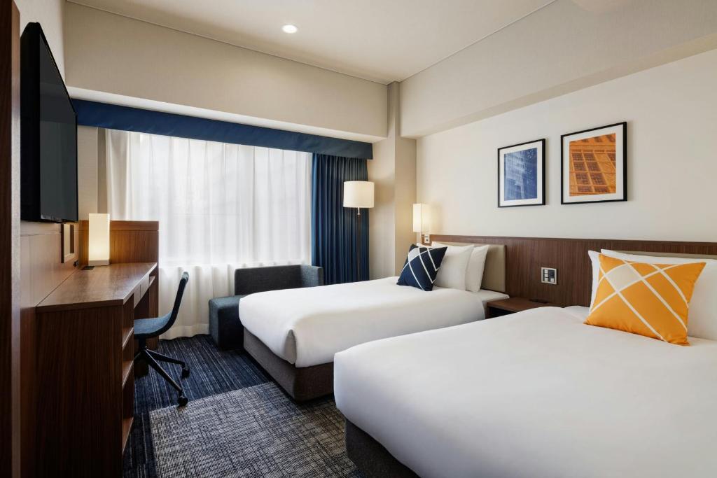 Postel nebo postele na pokoji v ubytování Four Points Flex by Sheraton Osaka Shinsaibashi