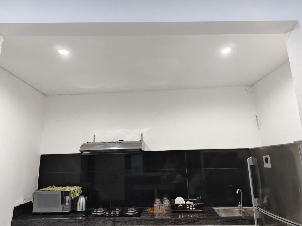 eine Küche mit schwarzen und weißen Wänden und einem Herd in der Unterkunft Two Bed Room Villa with Pool in Jimbaran