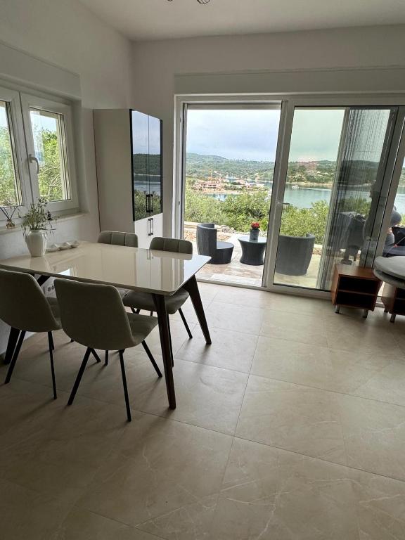 a living room with a table and chairs and a large window at Kuća za podmor Olea in Nečujam