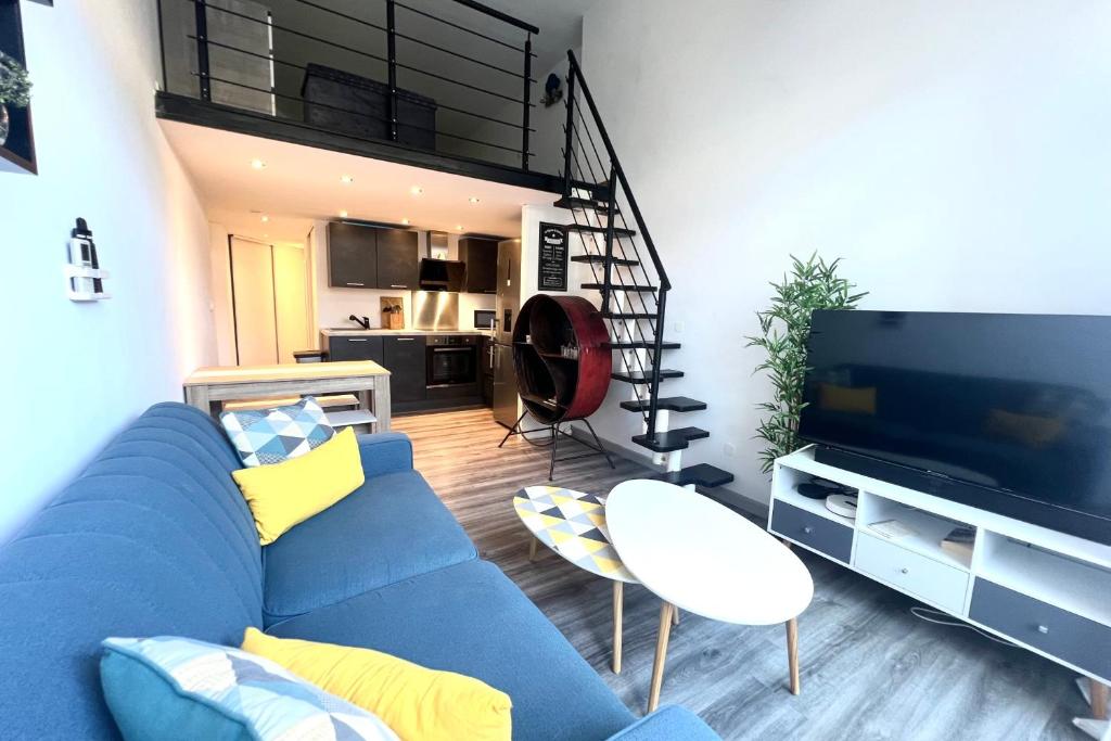 un salon avec un canapé bleu et une cuisine dans l'établissement Golfe Juan - 4 People - Swimming Pool - Parking, au Golfe-Juan