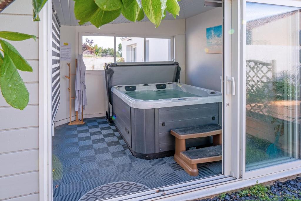 a jacuzzi tub in a room with a window at les Alizés in Notre-Dame-de-Monts