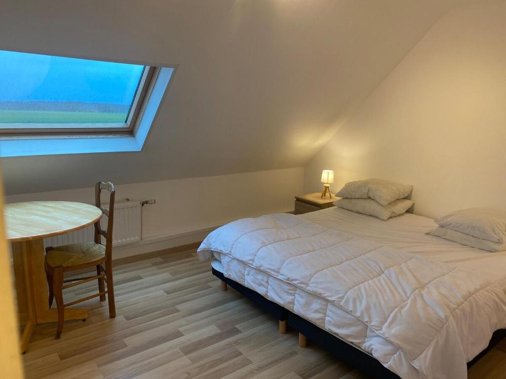 una camera da letto con un letto, un tavolo e una finestra di la Capitainerie de Petrus 06 a Saint-Étienne-au-Mont