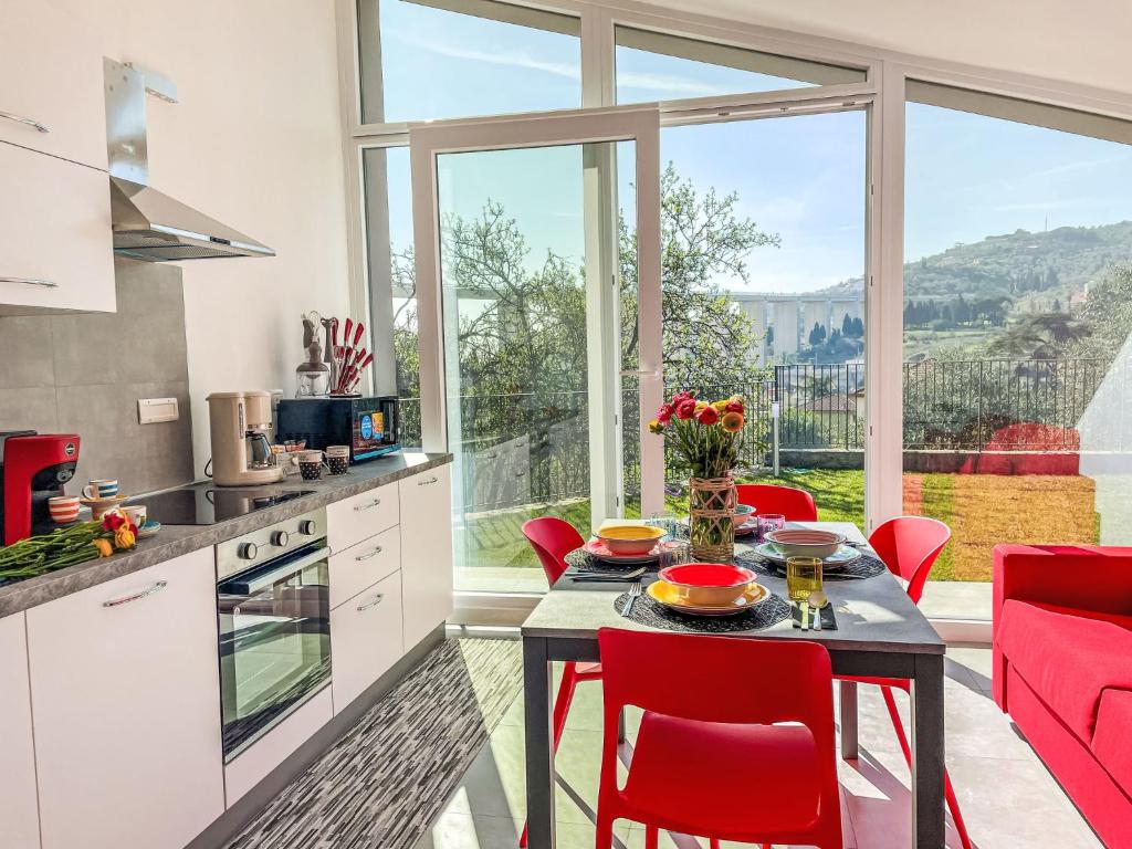 a kitchen with red chairs and a table with a table at Holiday Home Villa Milu by Interhome in Imperia