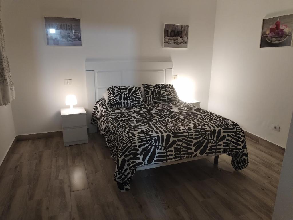 ein Schlafzimmer mit einem Bett mit einer schwarz-weißen Bettdecke in der Unterkunft Vista Puerto Studio 1 Pers No balcon in Arguineguín
