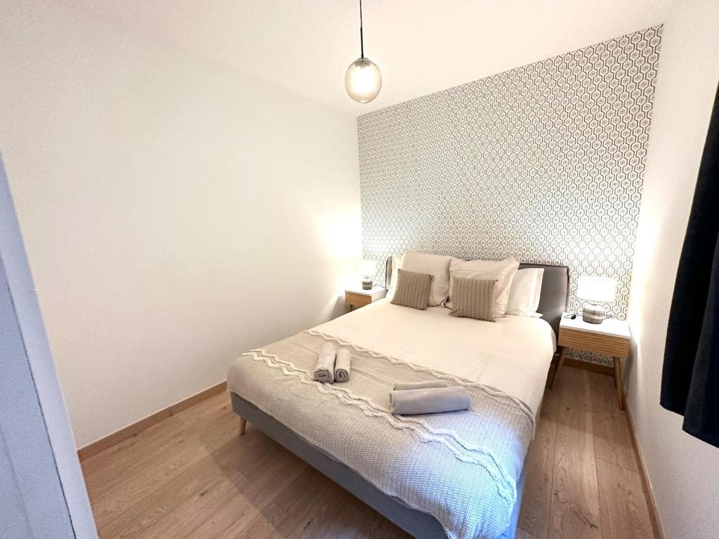 une chambre avec un lit avec deux chaussures dessus dans l'établissement 3 - Hypercentre, FREE Parking, Climatisation, wifi, netflix, à Libourne