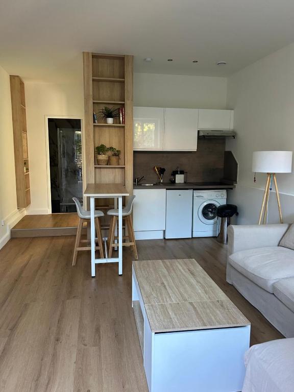 un salon avec un canapé blanc et une cuisine dans l'établissement Cosy 2 p au coeur de menton, à Menton