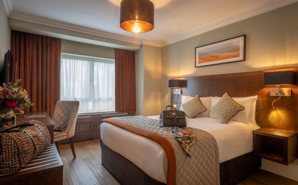 a hotel room with a bed with a bag on it at Glenroyal Hotel in Maynooth