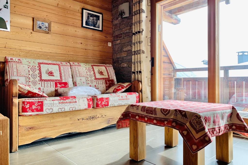 a wooden couch in a room with a table at #AH15 Les Chalets d'Ysalis in LʼHuez