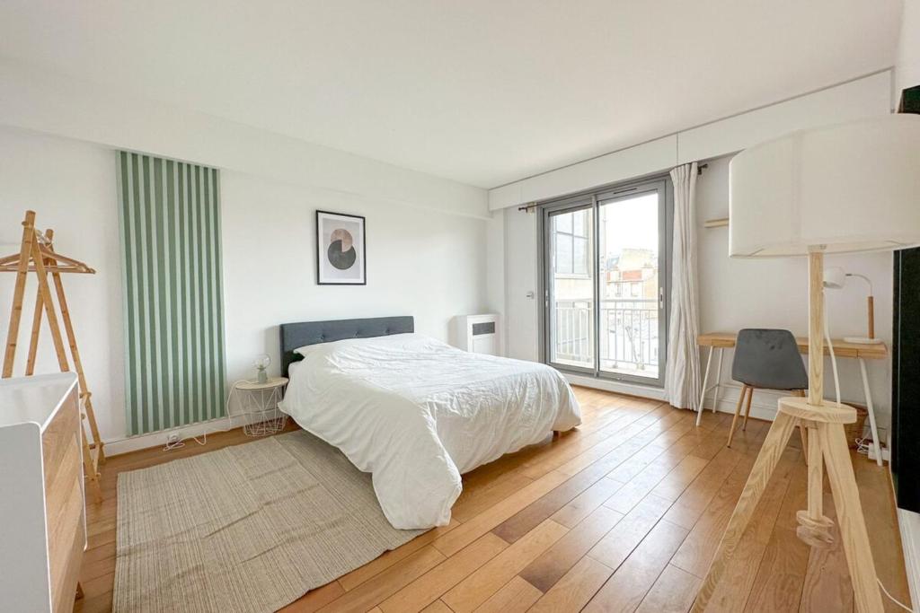 une chambre blanche avec un lit et une grande fenêtre dans l'établissement Flexliving - room - Ternes, à Paris