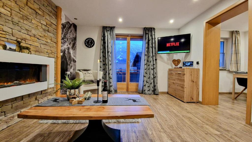 a living room with a fireplace and a tv at Kienberg - Modernes 2-Zimmer-Apartment im Allgäu-Stil mit Alpenpanorama in zentraler Lage in Pfronten in Pfronten