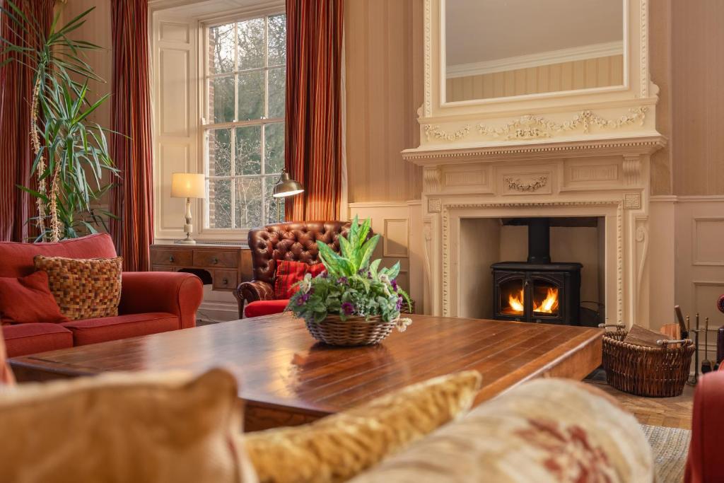 ハンマンビーにあるFamily friendly, big beautiful 17th Century houseのテーブルと暖炉のあるリビングルーム