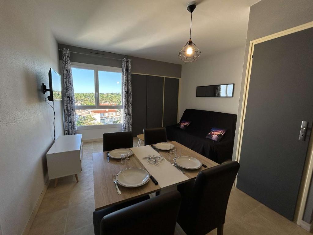 une salle à manger avec une table, des chaises et un canapé dans l'établissement Bel appartement 2 pièces à Saint-Jean-de-Monts, à 50m de la plage, avec parking privé - FR-1-224C-544, à Saint-Jean-de-Monts
