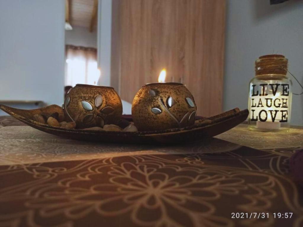 two wooden objects with a candle on a table at Christos Family Apartments Β in Ágios Rókkos