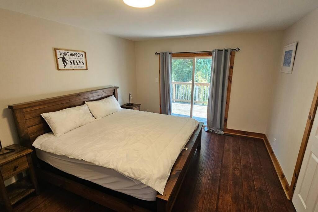 a bedroom with a large bed and a window at All-Season 8BR Vacation Chalet in Blue Mountains