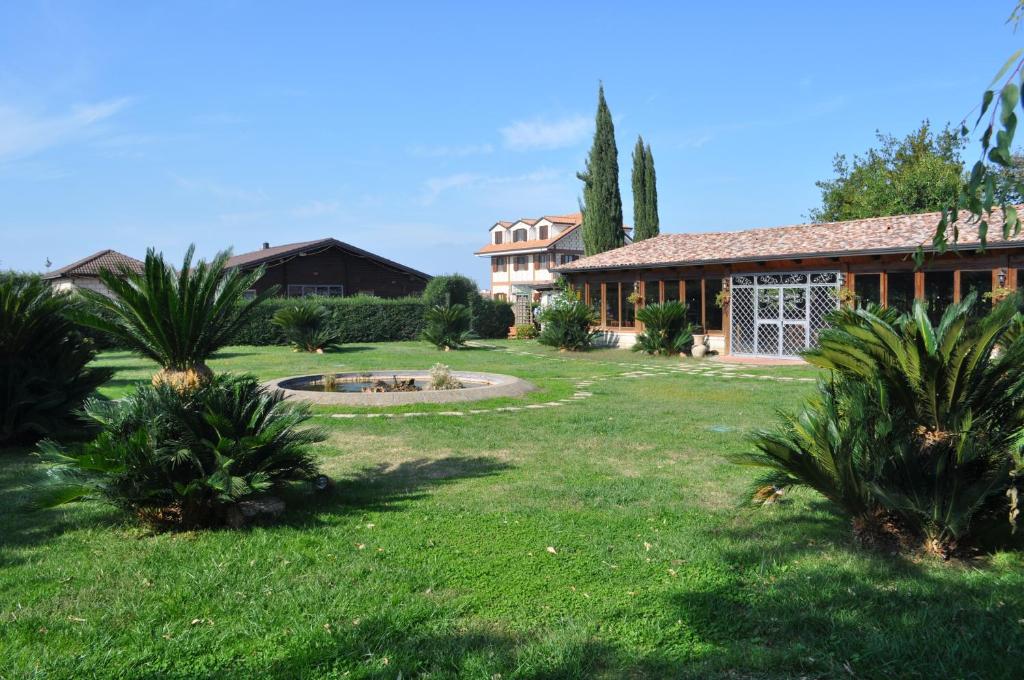 una casa con un cortile con palme di Agriturismo La Colombaia a Capua