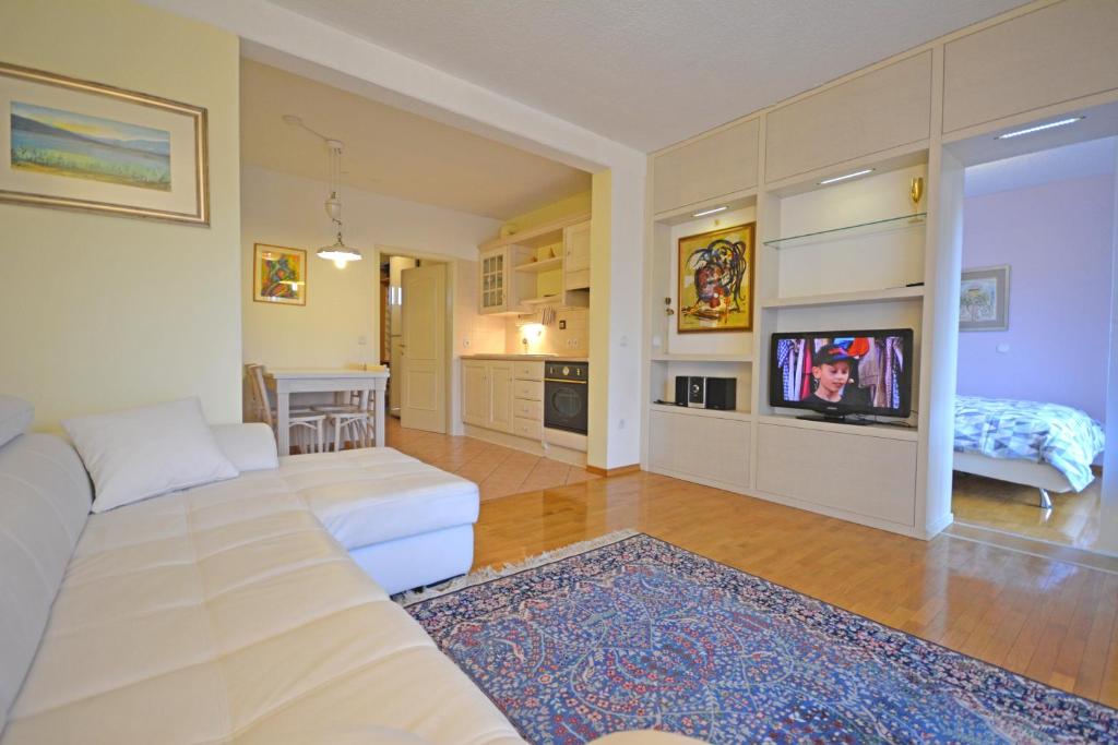 sala de estar con sofá y TV en Apartment Amigo, en Bled
