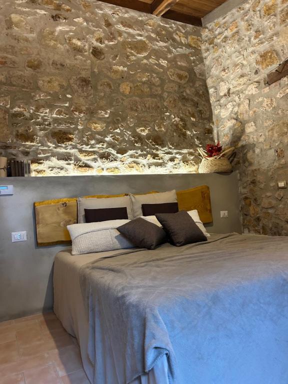 チビタベッキアにあるAntica Pietraの石の壁に大きなベッドが置かれた寝室