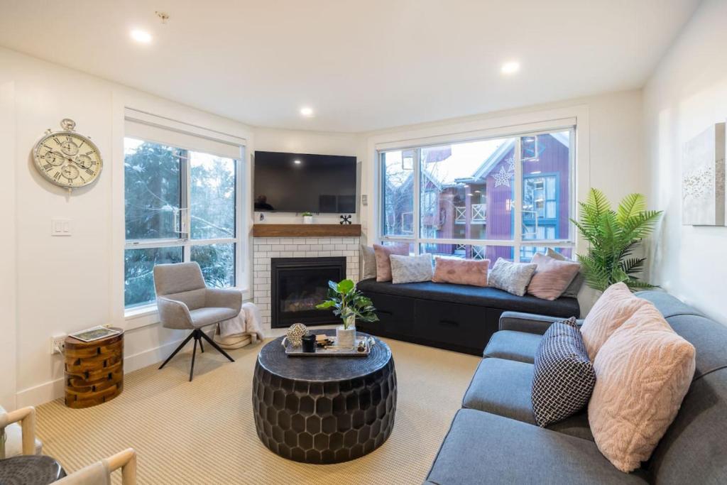 a living room with a blue couch and a fireplace at Whistler Village 2BR, Sleeps 6, Air Con, Free Parking in Whistler