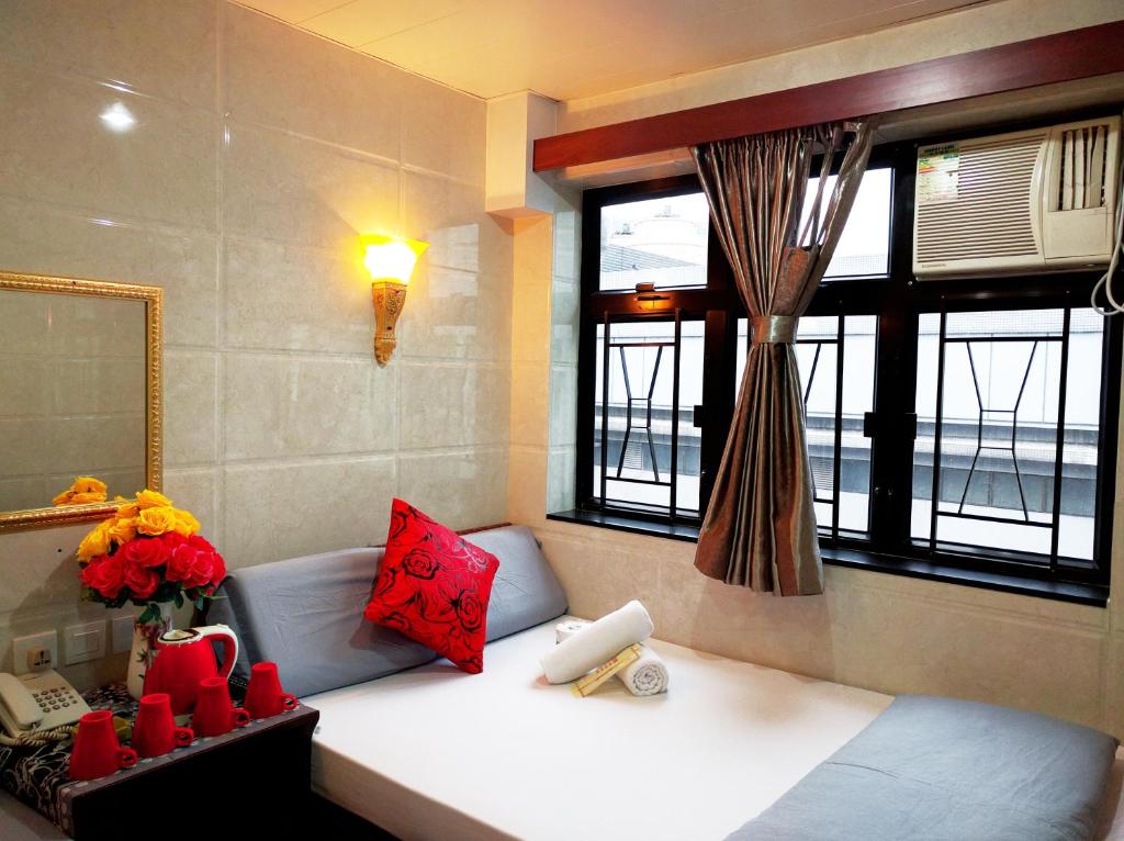 Habitación con cama con espejo y ventana en Budget Hostel Block D 10th Floor, en Hong Kong